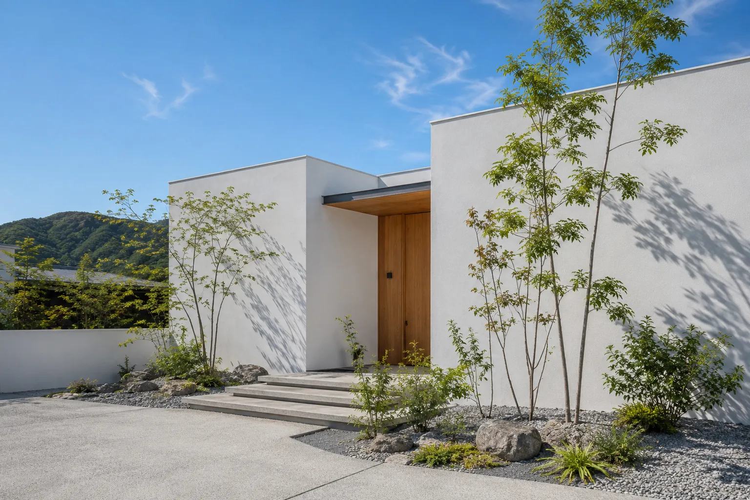 植栽と馴染む白い外壁の完成した住宅外観